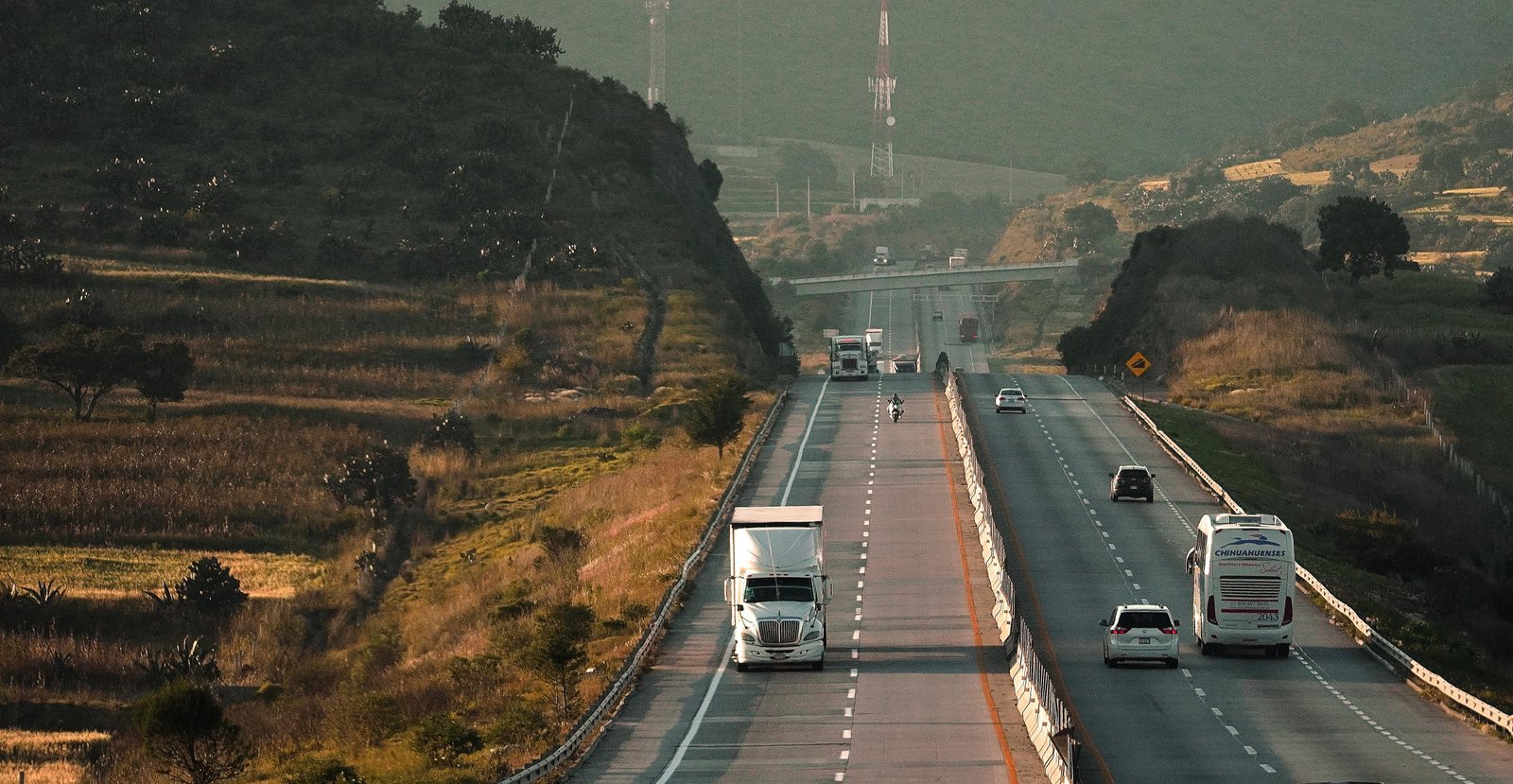 A bustling highway scene showcasing various vehicles traveling through a picturesque landscape.